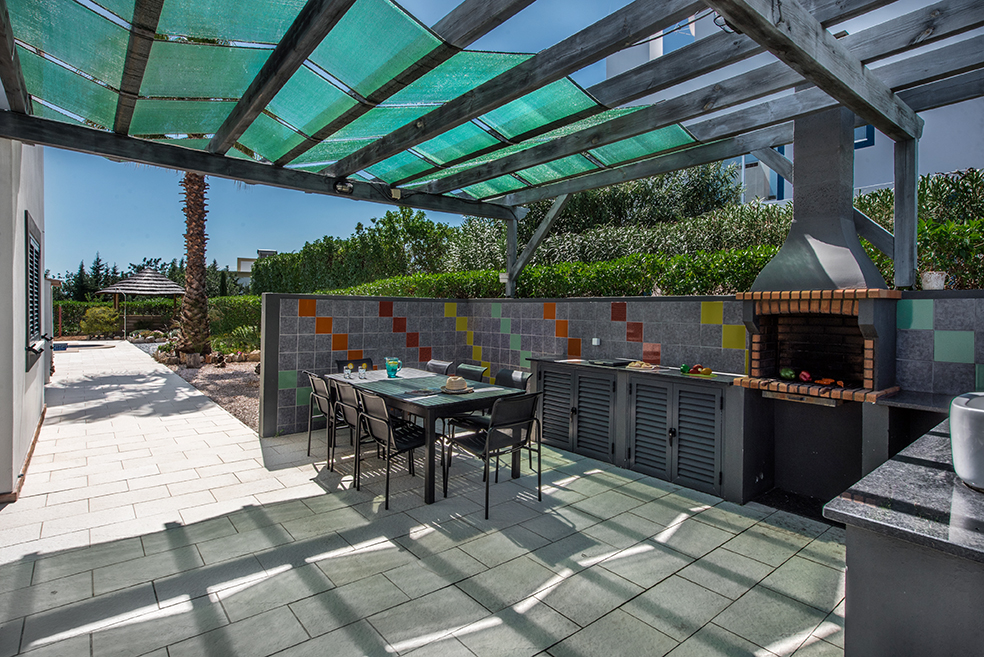 Ajacent to the kitchen youll find the BBQ area with fiited BBQ, with outdoor kitchen and table and chairs